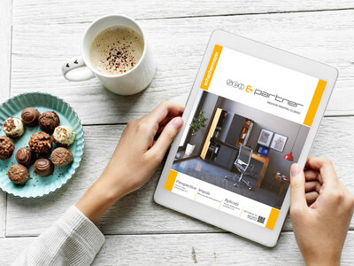 SCH&Partner online Doamna vizioneaza revista SCH&Partner pe tableta alaturi cu cafea si bomboane